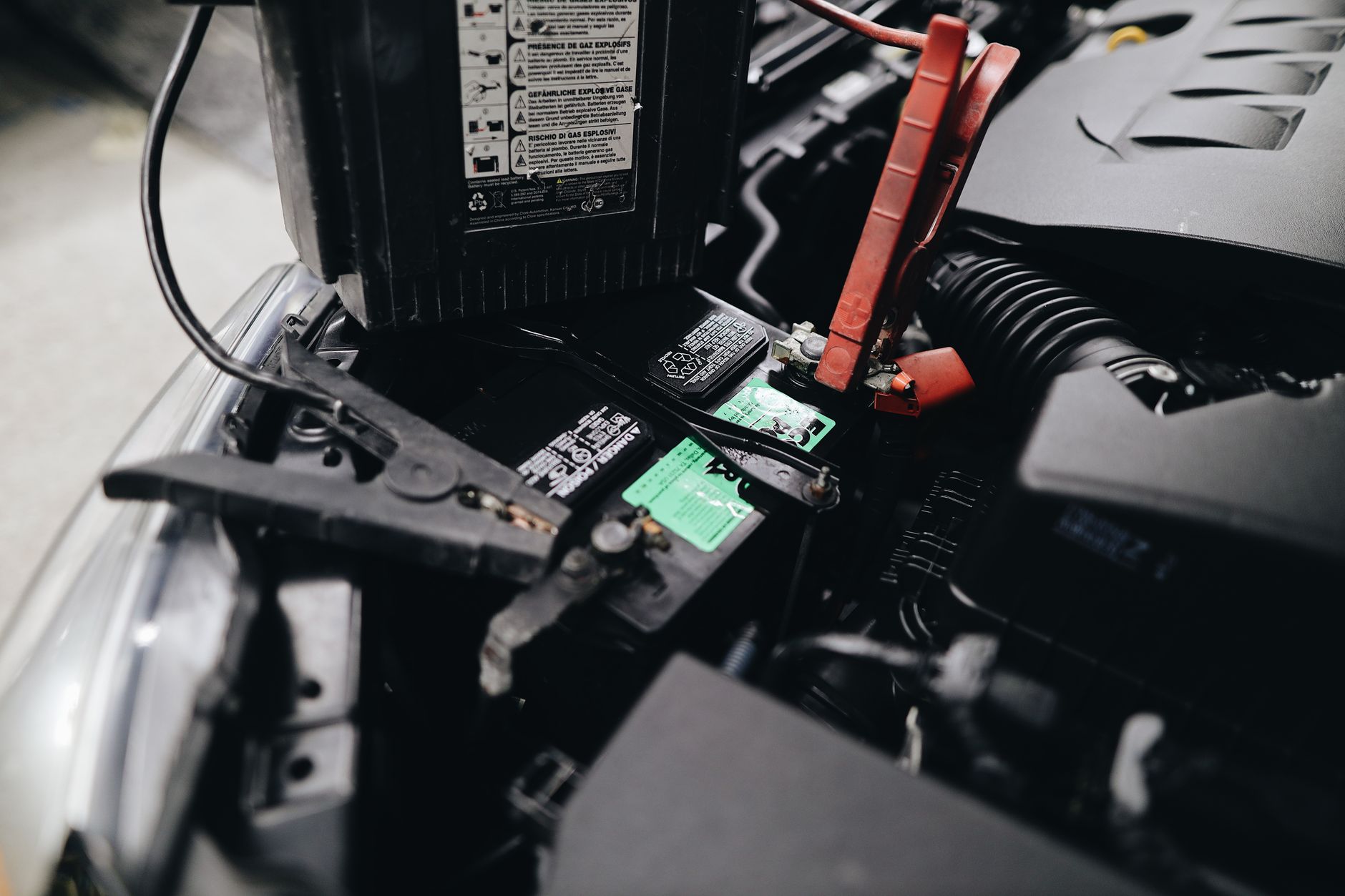 Technician testing 48V auxiliary battery as part of mild hybrid servicing procedure